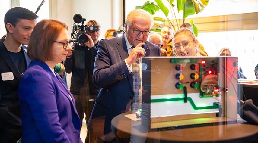 Bundespräsident Frank-Walter Steinmeier und Staatssekretärin Sandra Boser vom baden-württembergischen Kultusministerium lassen sich beim Finale 2024 die besten KI-Projekte erklären.